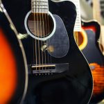Acoustic,Guitars,Of,Different,Types,And,Colors,Are,Hanging,In