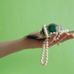 Hand,Holding,Vintage,Silver,Bracelet,With,Green,Stones,,Pearls,Necklace