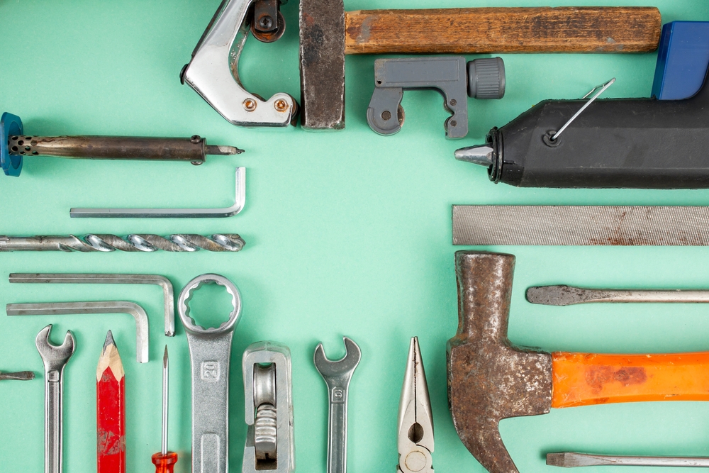Multiple,Hand,Tools,Arranged,On,Green,Background,,With,Empty,Square